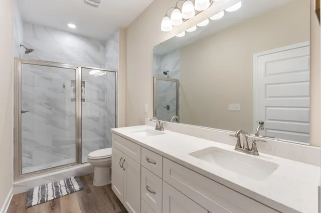 a bathroom with a sink a toilet and shower