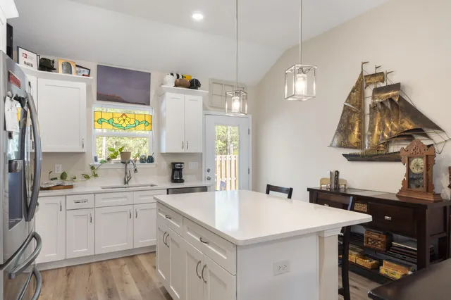 a kitchen with a sink a stove a refrigerator and a window