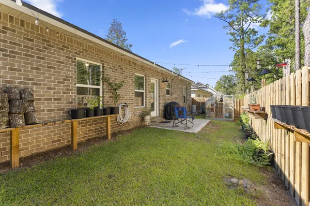 a view of a chair and table in backyard of the house