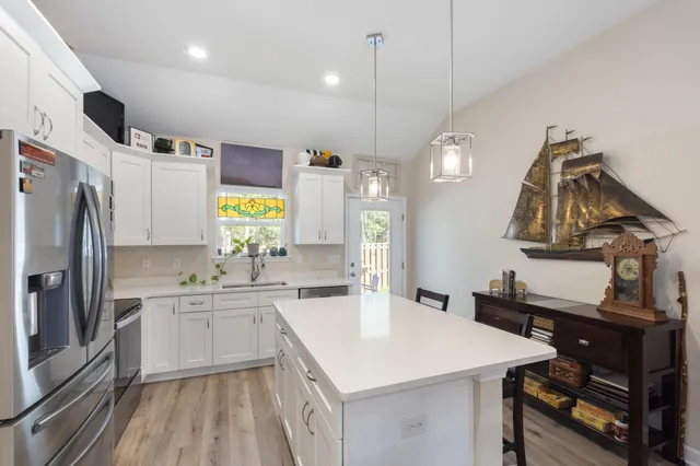 a kitchen that has a lot of cabinets and wooden floor