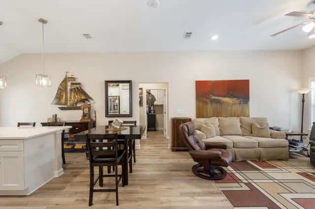a kitchen with stainless steel appliances kitchen island granite countertop a dining table chairs and white cabinets