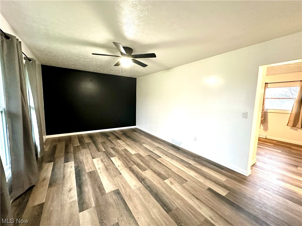 2039 St Johns Road Colliers, WV 26035 - Photo 2 of 35 Unfurnished room featuring dark hardwood / wood-style flooring, a textured ceiling, and ceiling fan