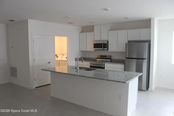 a kitchen with stainless steel appliances granite countertop a sink a refrigerator a stove a microwave and cabinets