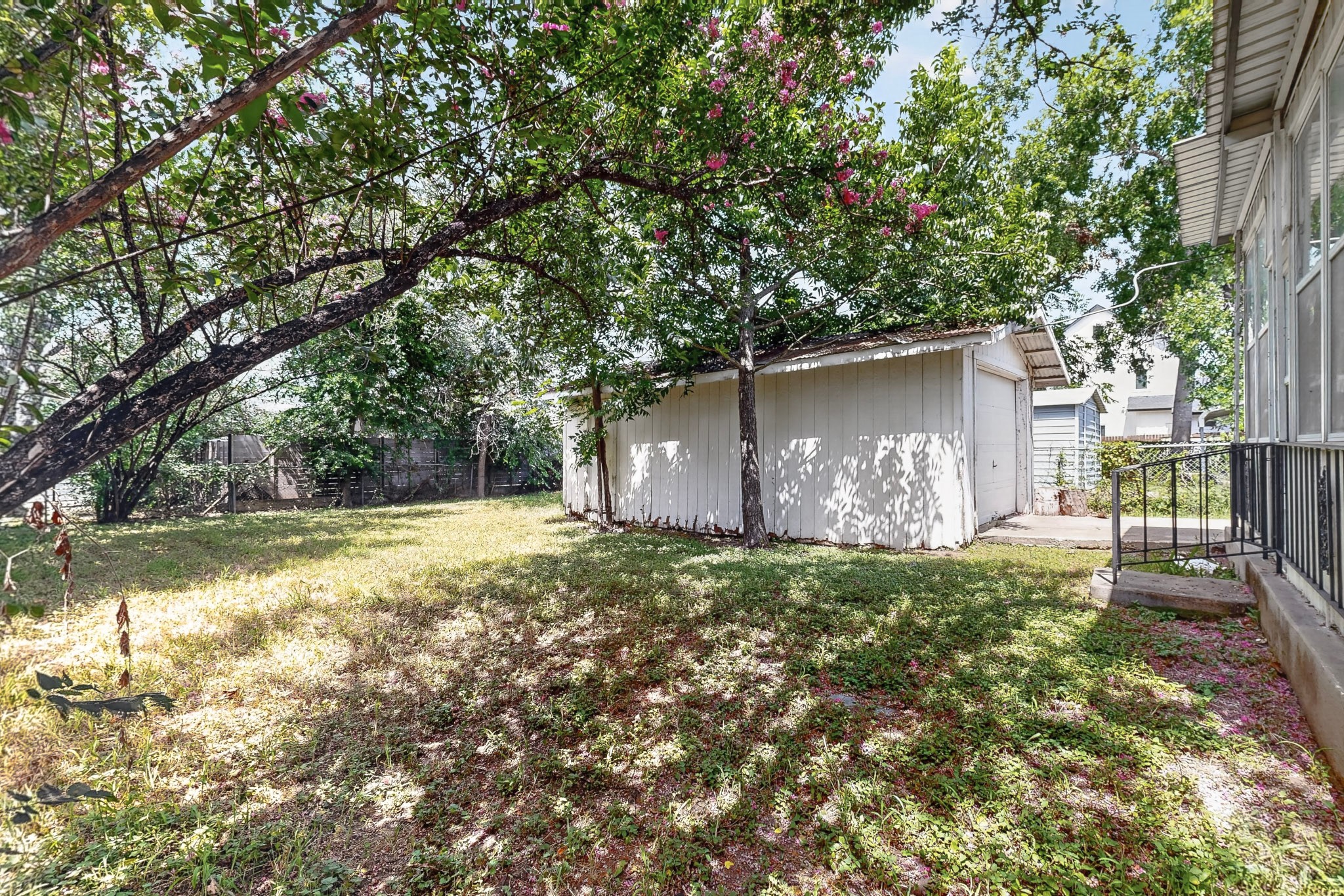 4703 Leslie Avenue Austin, TX 78721 - Photo 32 of 34 Mature trees shade a private backyard, featuring a functional storage shed for all your outdoor needs.