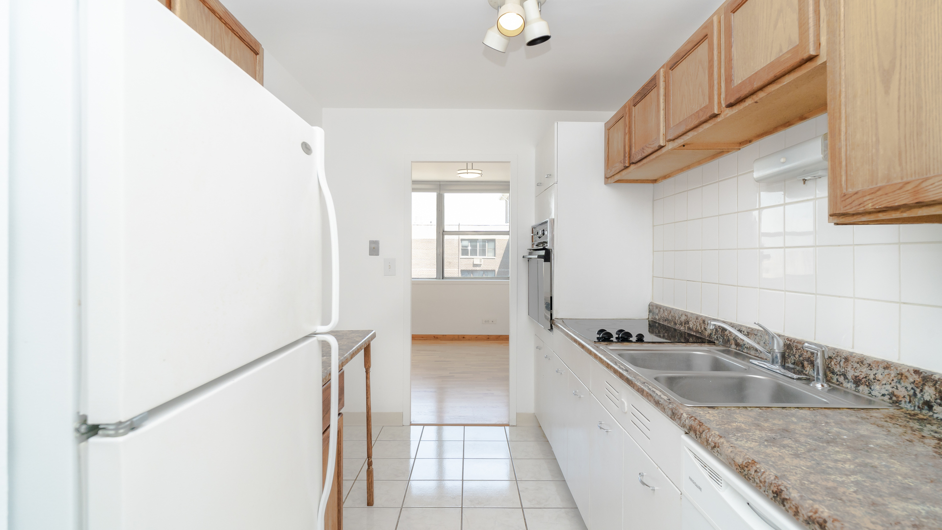 6301 North Sheridan Road, Unit 22B Chicago, IL 60660 - Photo 6 of 14 a kitchen with a sink and a refrigerator
