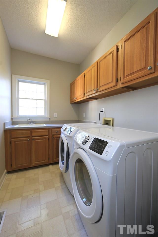 5628 Raddington Street Raleigh, NC 27613 - Photo 22 of 25 Separate laundry room with cabinets and laundry sink.
