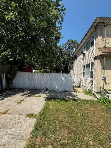 a backyard of a house with wooden fence and trees