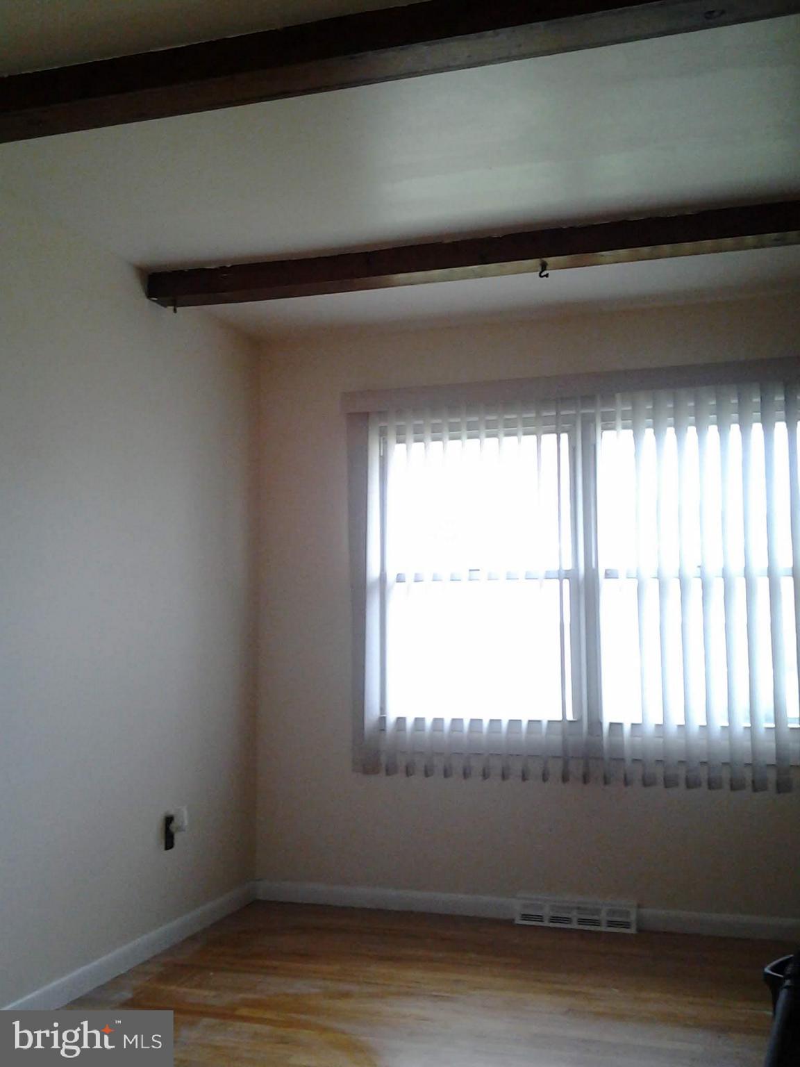 3113 Rheims Road Baltimore, MD 21244 - Photo 5 of 16 a view of an empty room with wooden floor and a window