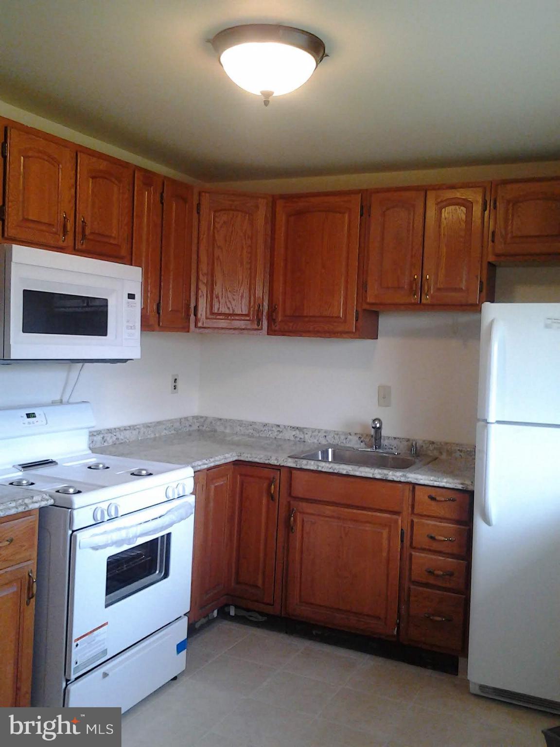 3113 Rheims Road Baltimore, MD 21244 - Photo 7 of 16 a kitchen with a sink stove top oven and cabinets