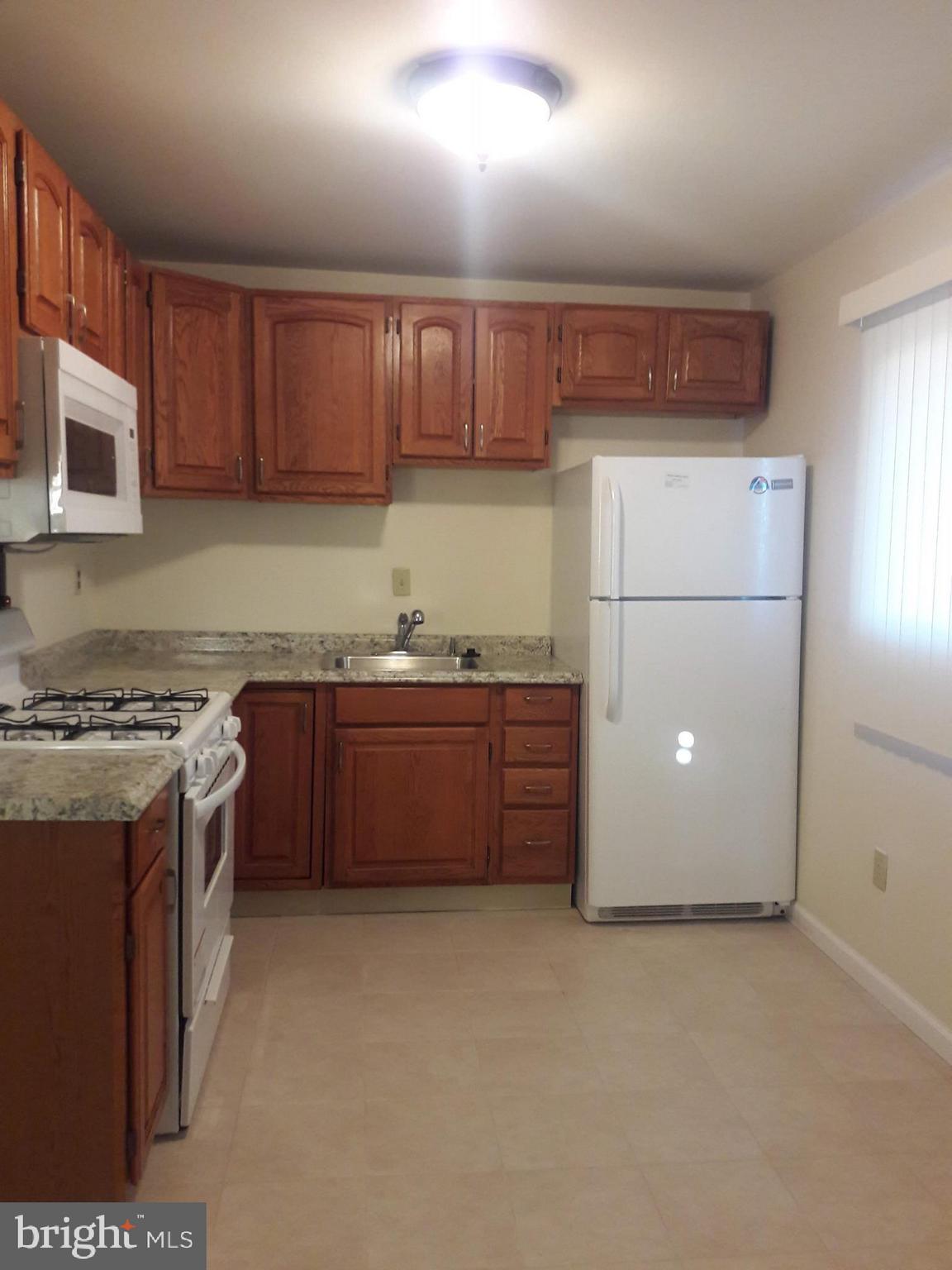 3113 Rheims Road Baltimore, MD 21244 - Photo 8 of 16 a kitchen with granite countertop a refrigerator and a stove
