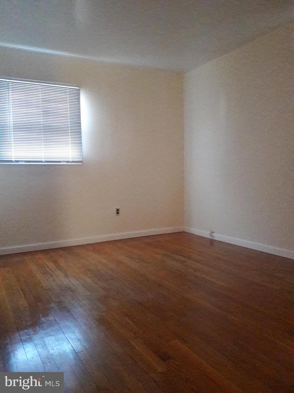 3113 Rheims Road Baltimore, MD 21244 - Photo 9 of 16 a view of an empty room with wooden floor and a window