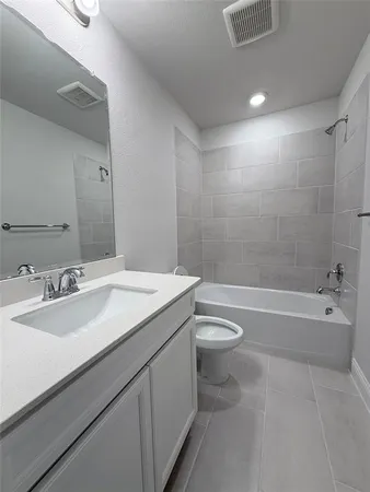 a bathroom with a granite countertop sink a toilet and bathtub