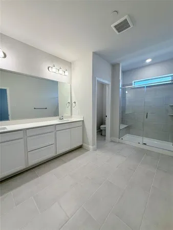 a bathroom with a double vanity sink mirror and shower