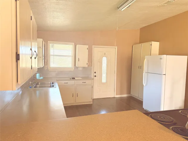 a open kitchen with a refrigerator a sink and a large window