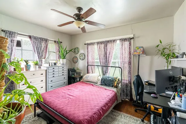 a bed room with a bed window and a potted plant
