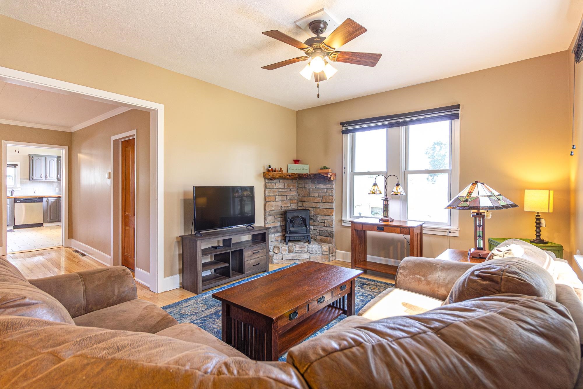 1151 East Camp Street Ely, MN 55731 - Photo 11 of 45 Living room with light hardwood / wood-style flooring, ceiling fan, and a wood stove