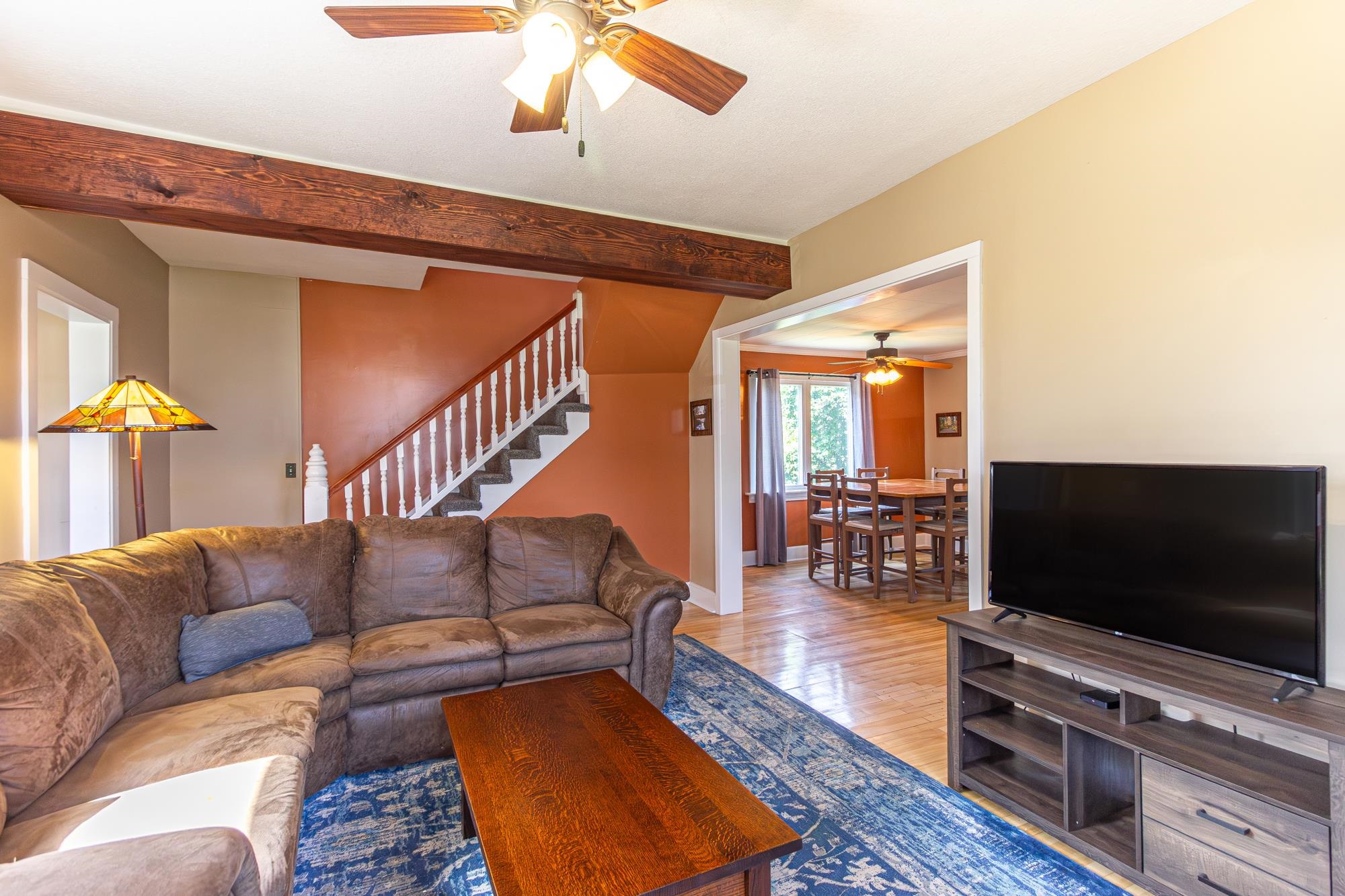 1151 East Camp Street Ely, MN 55731 - Photo 9 of 45 Living room featuring light hardwood / wood-style floors, beam ceiling, and ceiling fan