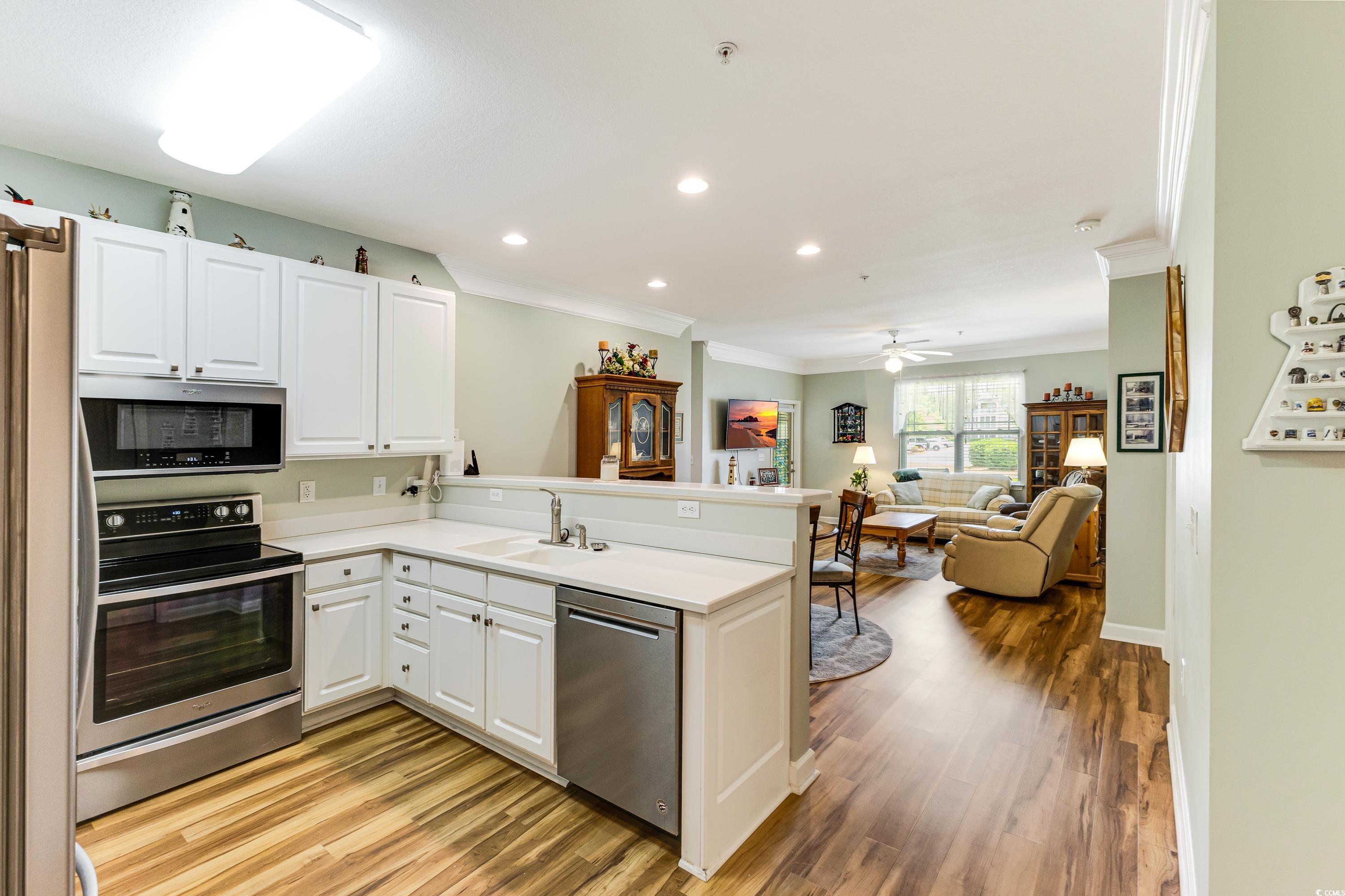 260 Woodlands Way, Unit 2 Calabash, NC 28467 - Photo 5 of 40 Kitchen with stainless steel appliances, a sink, ornamental molding, a peninsula, and recessed lighting