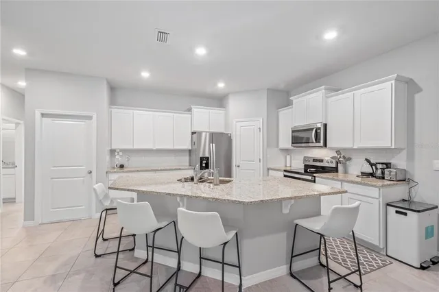 a kitchen with a sink cabinets stainless steel appliances and a window