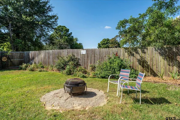 a view of backyard with table and chairs