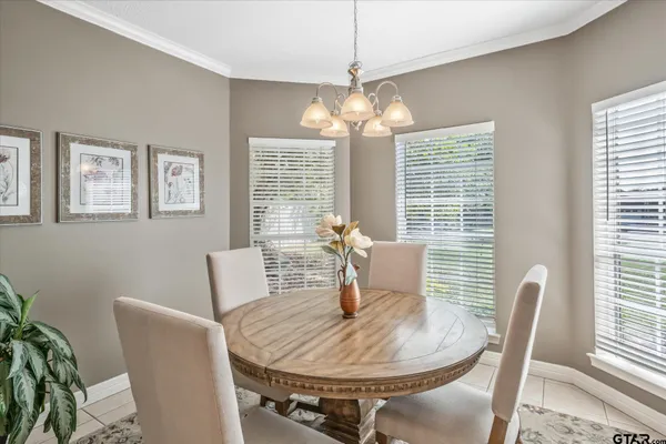 a dining room with furniture a chandelier and window