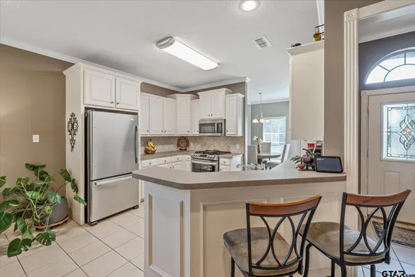 a kitchen with a stove and white cabinets