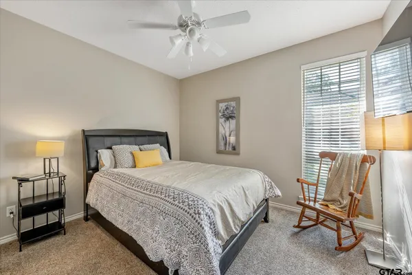 a bedroom with a bed a lamp and a large window