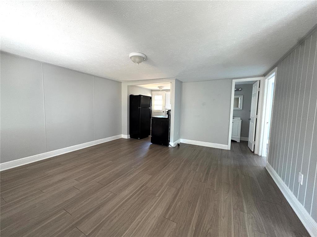 4611 North Hubert Avenue, Unit 11 Tampa, FL 33614 - Photo 4 of 10 a view of an empty room with wooden floor and a window