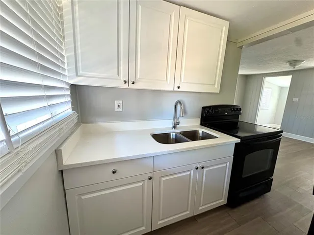 a kitchen with white cabinets a sink and dishwasher