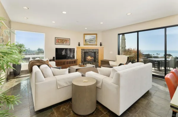 a living room with fireplace furniture and a large window