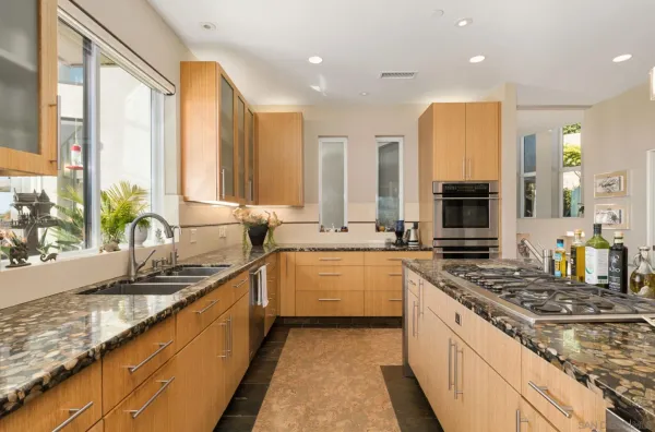 a large kitchen with stainless steel appliances granite countertop a sink stove and cabinets