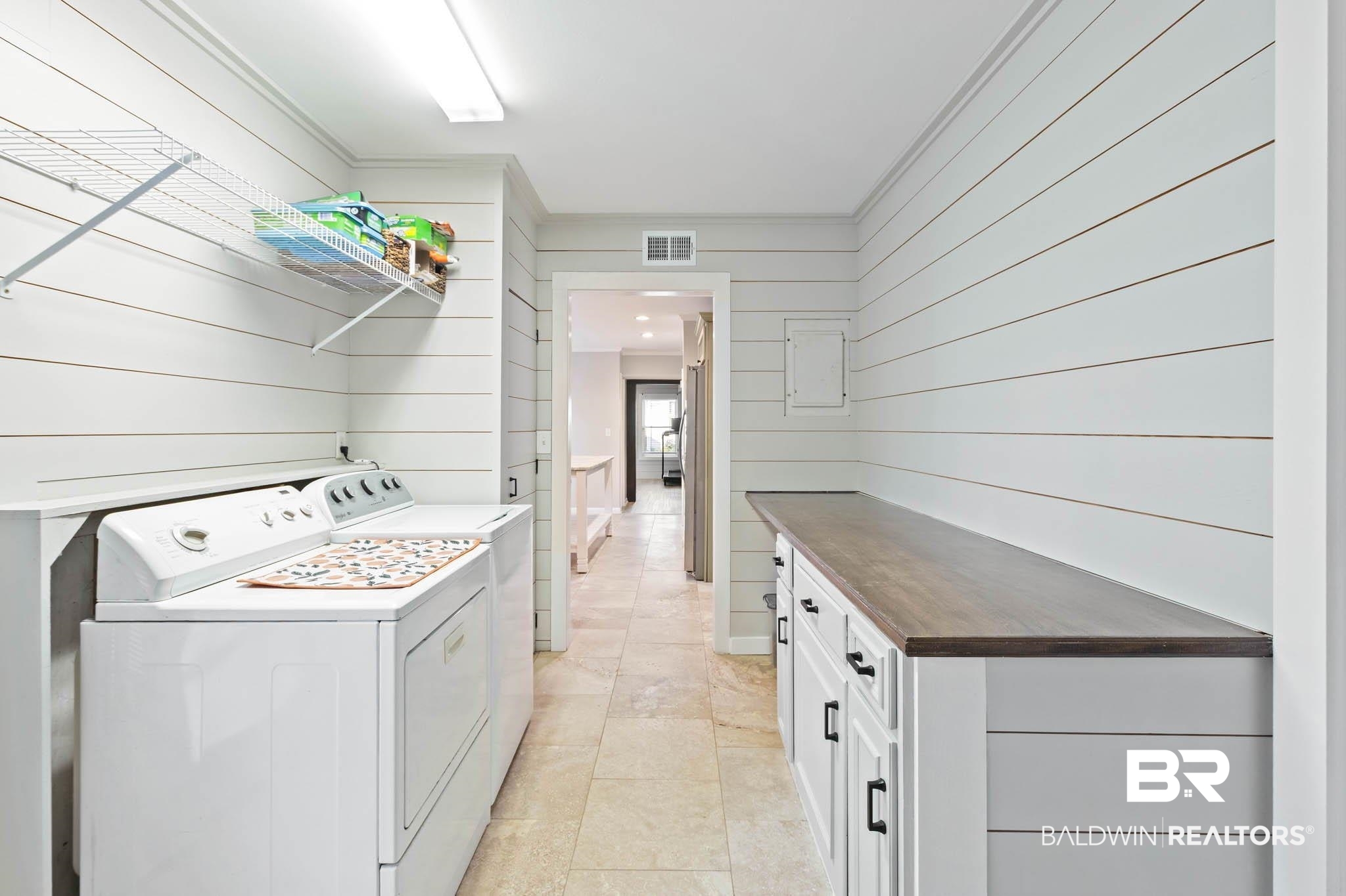 608 Southern Way Daphne, AL 36527 - Photo 29 of 35 Laundry room with wooden walls, washer and dryer, ornamental molding, light tile patterned floors, and cabinet space