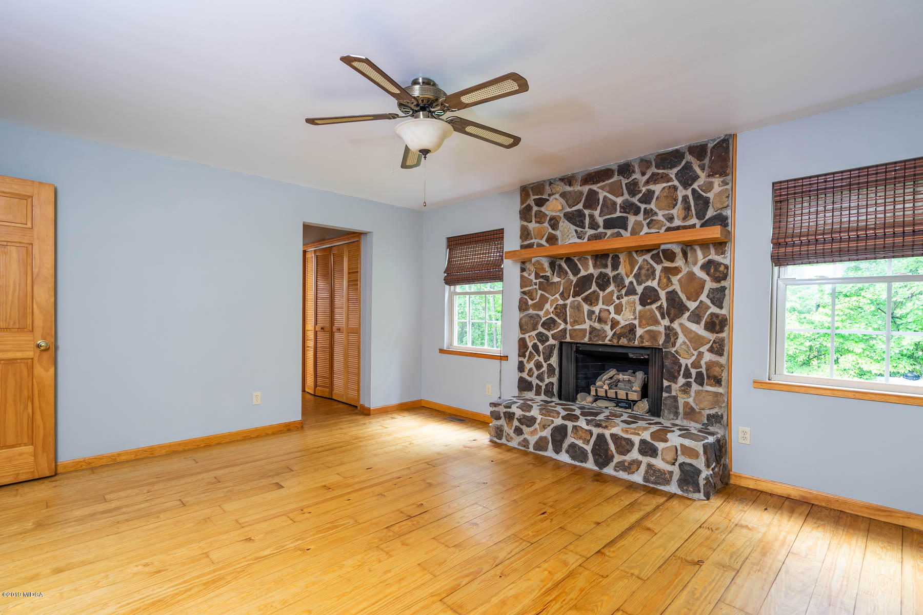 5934 Dames Ferry Road Juliette, GA 31046 - Photo 16 of 41 a view of a livingroom with a fireplace a ceiling fan and wooden floor