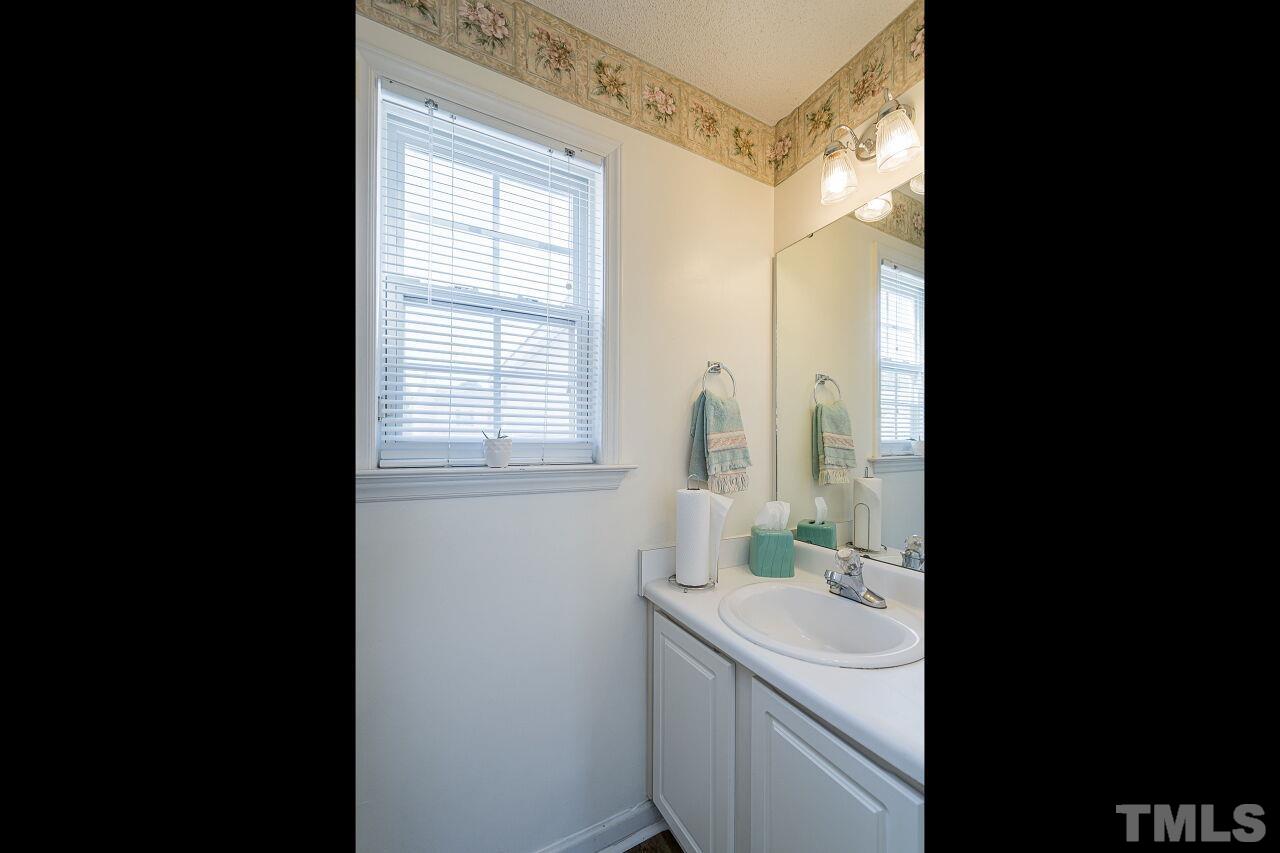 4428 Moss Spring Drive Raleigh, NC 27616 - Photo 15 of 27 a bathroom with a sink and mirror with window