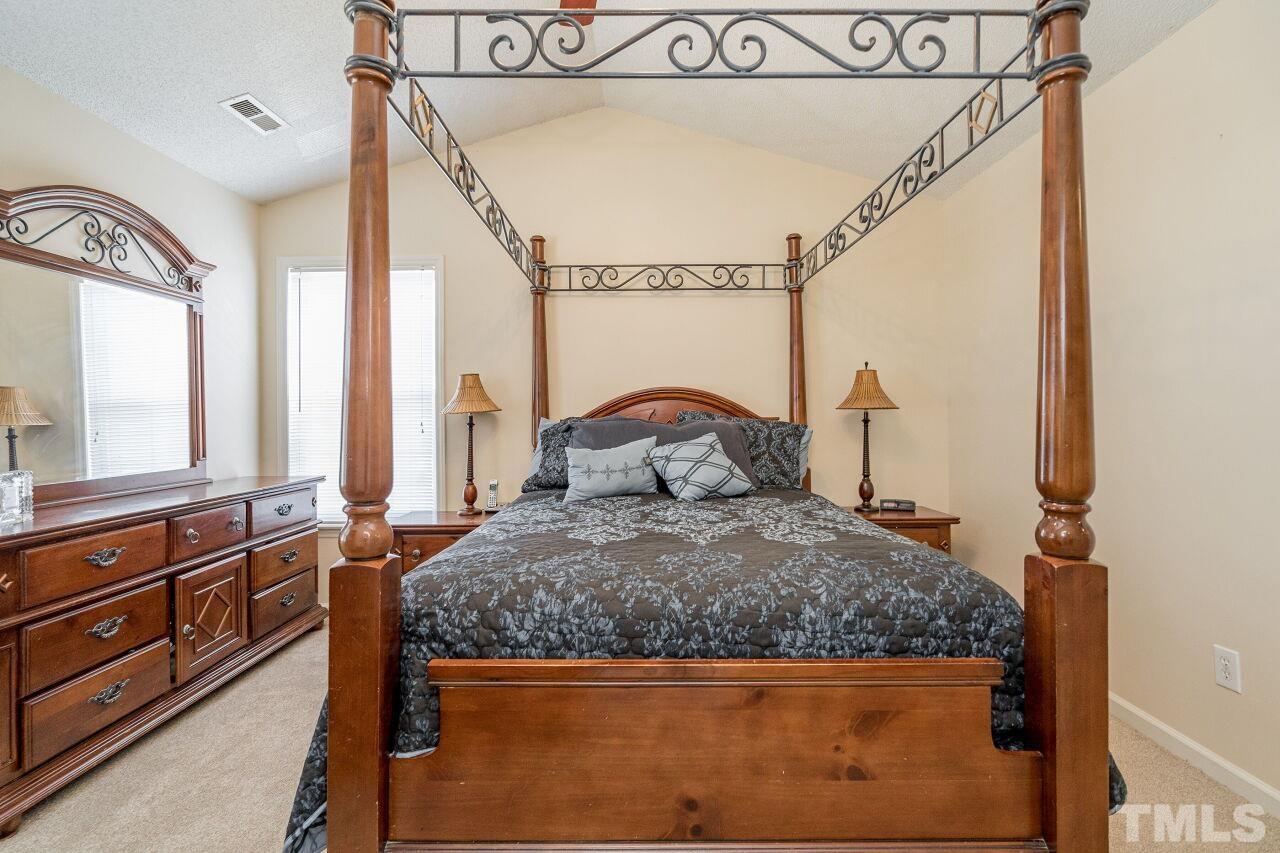 4428 Moss Spring Drive Raleigh, NC 27616 - Photo 17 of 27 a bedroom with a bed and a large mirror on the dresser