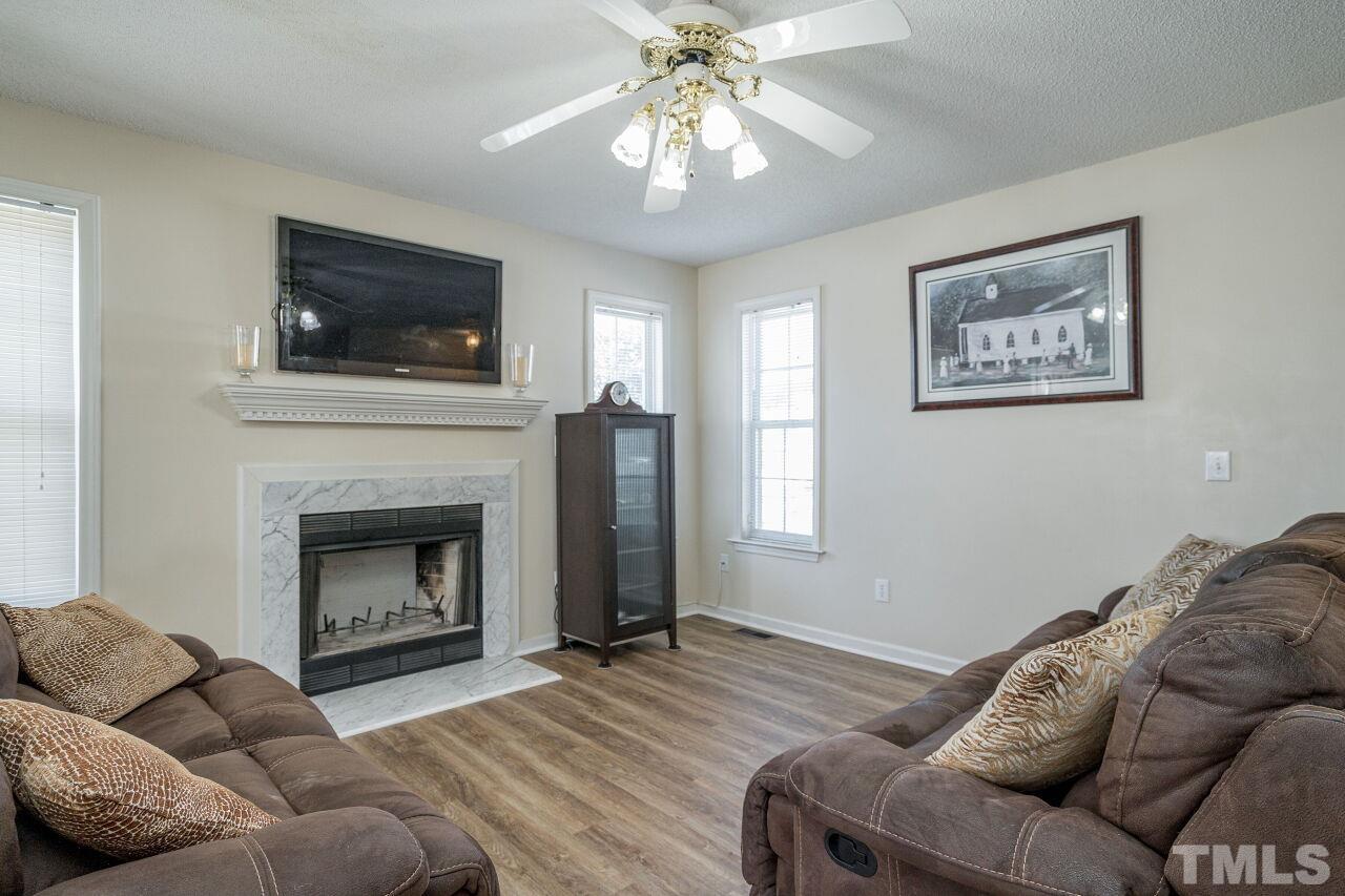 4428 Moss Spring Drive Raleigh, NC 27616 - Photo 5 of 27 a living room with furniture a flat screen tv and a fireplace