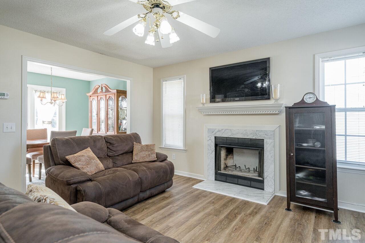 4428 Moss Spring Drive Raleigh, NC 27616 - Photo 8 of 27 a living room with furniture a flat screen tv and a fireplace