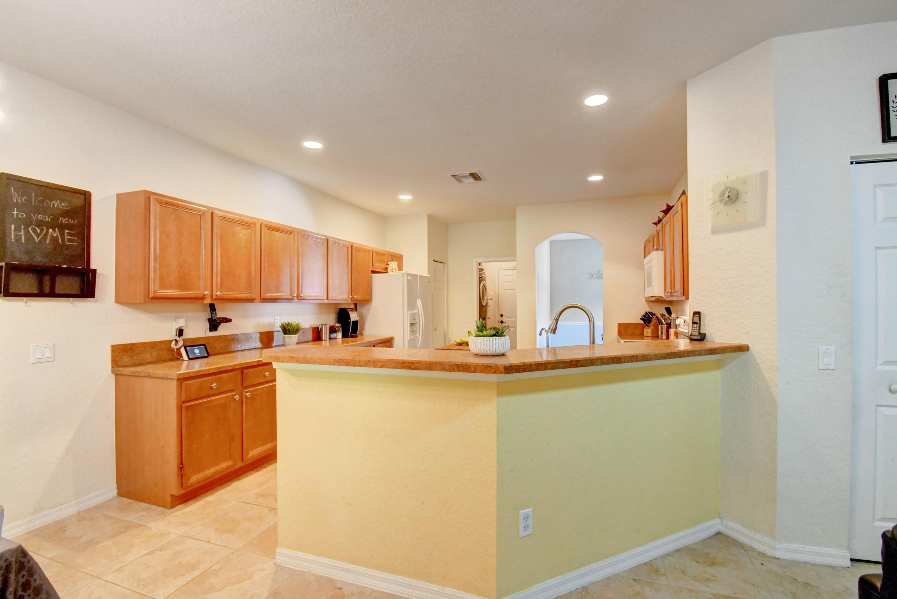 804 Quartz Terrace West Palm Beach, FL 33413 - Photo 16 of 65 a view of a kitchen with kitchen island a sink a stove and wooden floors