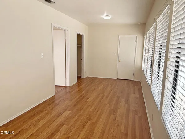 an empty room with wooden floor and a window
