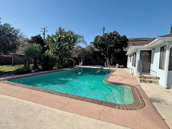 a view of a backyard with a garden and entertaining space