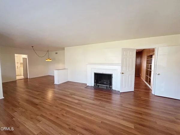 a view of empty room with wooden floor