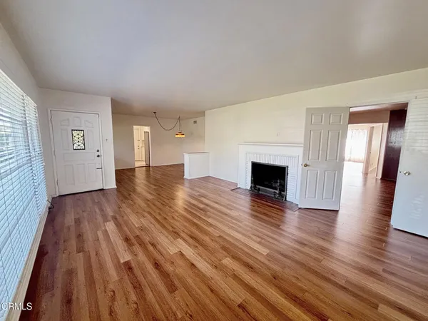 an empty room with wooden floor and fireplace