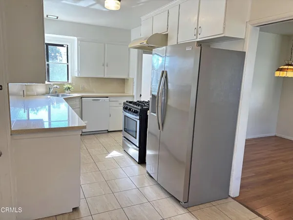 a kitchen with stainless steel appliances granite countertop a refrigerator and a sink