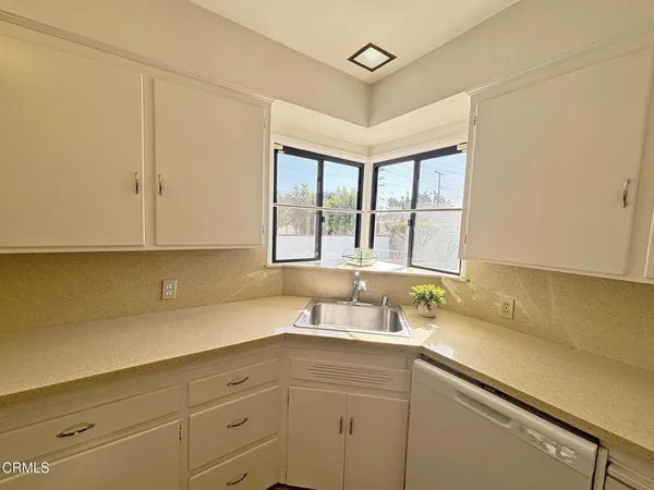 a kitchen with a sink cabinets and window