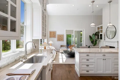 a kitchen with granite countertop a sink a counter top space and living room view