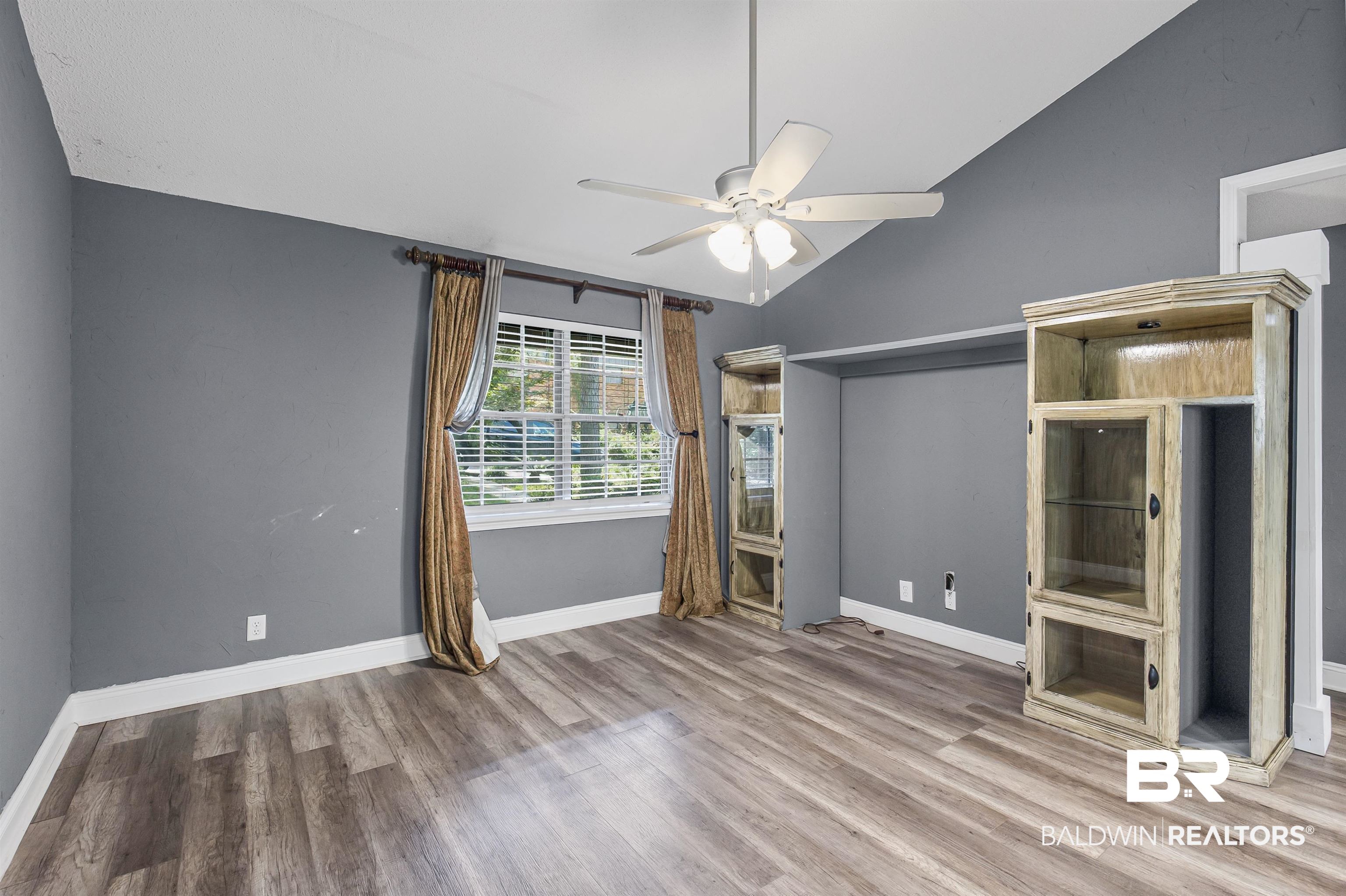 36 Ridgeview Drive Mobile, AL 36611 - Photo 6 of 20 Unfurnished living room with wood finished floors, vaulted ceiling, and ceiling fan