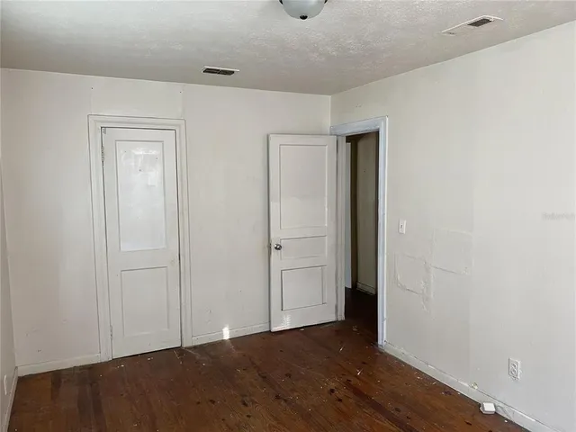 an empty room with wooden floor and closet