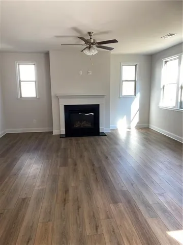 an empty room with windows a fireplace