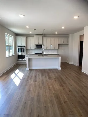 an open kitchen with kitchen island and stainless steel appliances