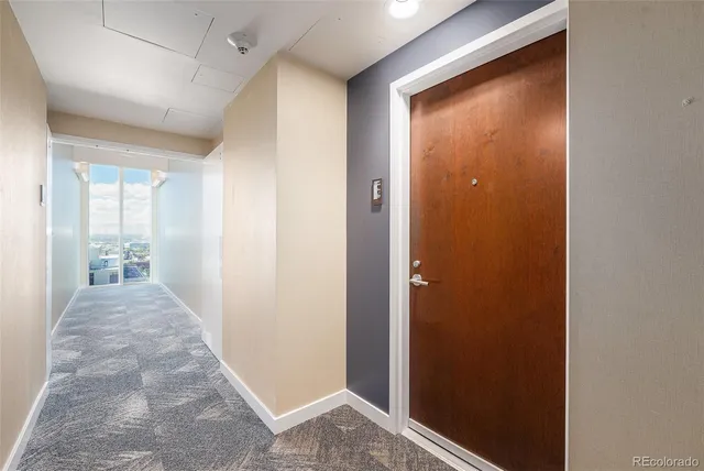 a view of a hallway with a livingroom and a bathroom space